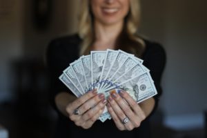 woman holding money, earning more